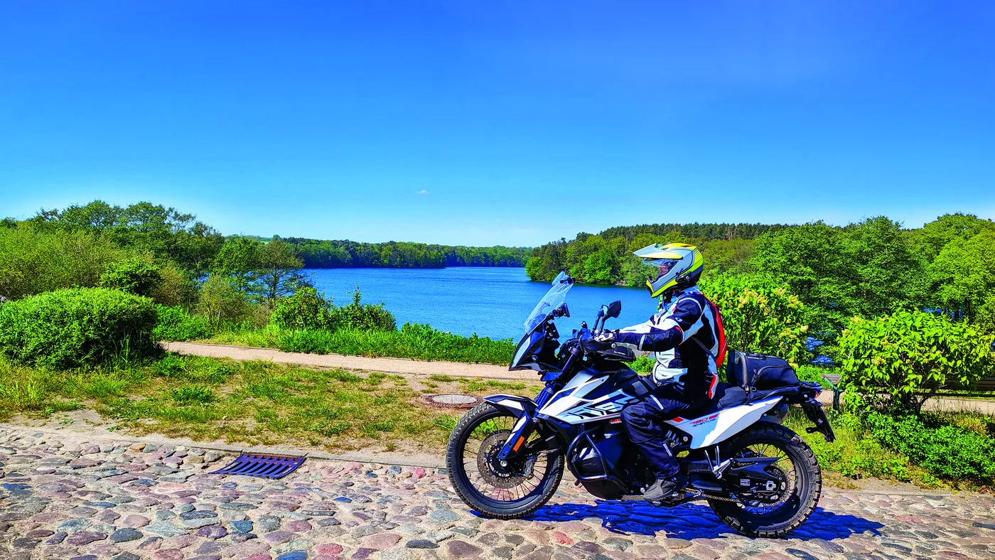 Motorrad am steinigen Ufer eines Sees
